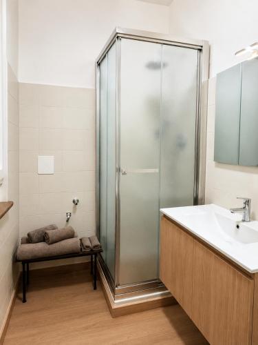 a bathroom with a glass shower and a sink at Nuara Urban Loft in Novara
