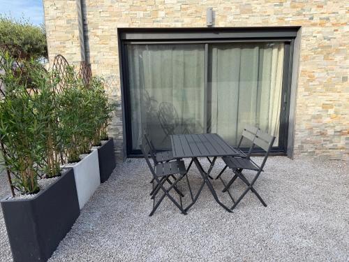 a picnic table and two chairs in front of a building at Douce Évasion in Beauvoisin