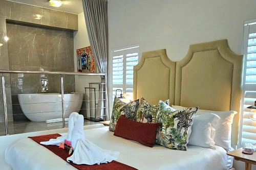 a bedroom with a large bed with a bath tub at Fleur du Soleil Luxury Guesthouse in Franschhoek
