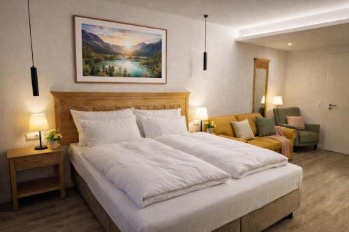 a bedroom with a large white bed and a couch at Hotel Night4Flight Hamburg-Airport in Hamburg