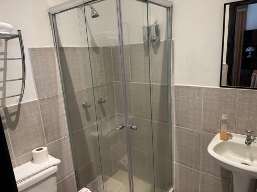 a shower with a glass door next to a sink at Mansión del Parque by CS in Guaranda