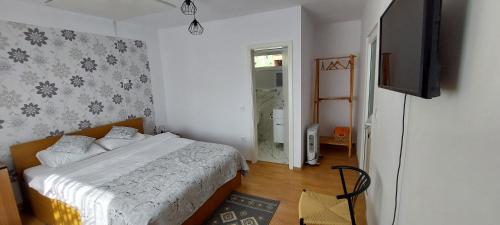a bedroom with a bed and a television in it at Casuta din Crang in Moieciu de Jos