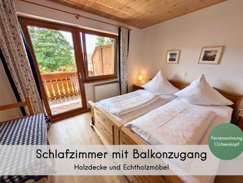 a bedroom with a bed and a large window at Gästehaus Philipp im Herzen des Fichtelgebirges - 5 Ferienwohnungen, großes Grundstück, Wald und Wiese, Wohnung mit privater Sauna, kostenfreie Parkplätze, WLAN in Mehlmeisel