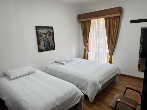 a bedroom with two beds and a window at Mansión del Parque by CS in Guaranda