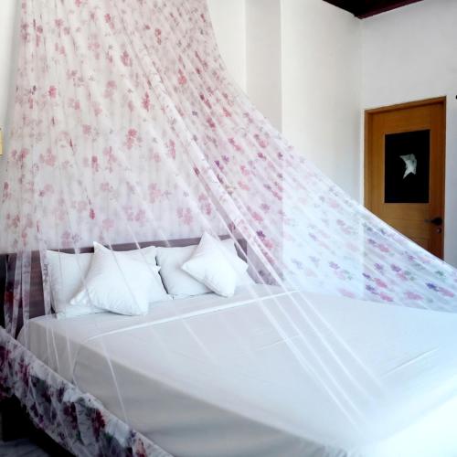 a bedroom with a white bed with a canopy at Chandi Mahal HomeStay in Kandy