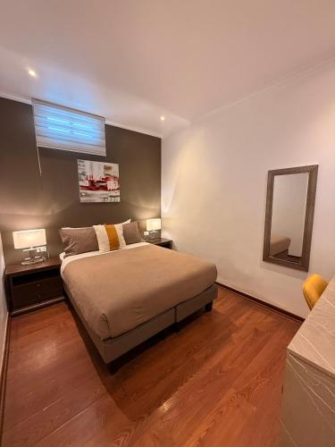 a bedroom with a large bed and a mirror at H Ocaranza in Santiago