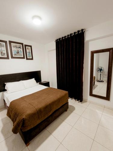 a bedroom with a large bed and a mirror at SANCA HOUSE Hostel in Trujillo
