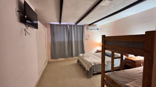 a bedroom with a bed and a television in a room at Hotel y Cabañas Gran Cordoba in La Falda