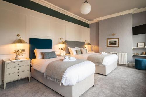 a bedroom with two beds and two tables and lamps at Creighton Hotel in Cluain Eois