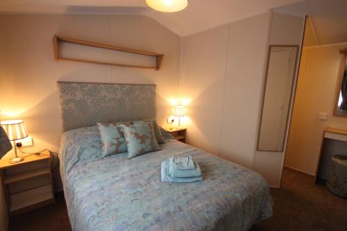 a bedroom with a bed with towels on it at The Trotting Mare Holiday Lets - Adults Only in Wrexham