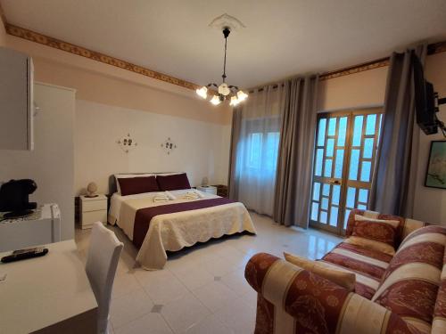 a large bedroom with a bed and a couch at b&b Il Siriaco in Calatabiano
