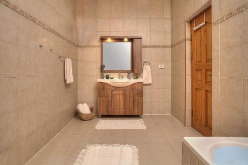 a bathroom with a sink and a mirror at קצה ההר in Amirim