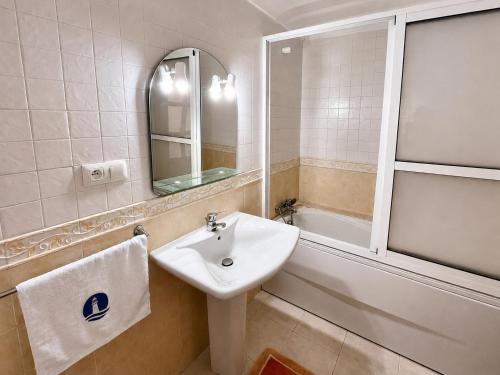a bathroom with a sink and a mirror and a bath tub at Elegant Beach View Apartment in Kabila Vista in Marina Smir