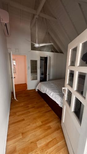 a bedroom with a bed and a wooden floor at Chill room front sea in Philipsburg