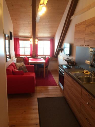 マウテルンドルフにあるStoff-Maurergütlのキッチン(赤いソファ付)、リビングルーム