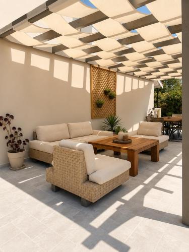 a living room with couches and a table and chairs at Euphoria Suites and Studios in Sidari