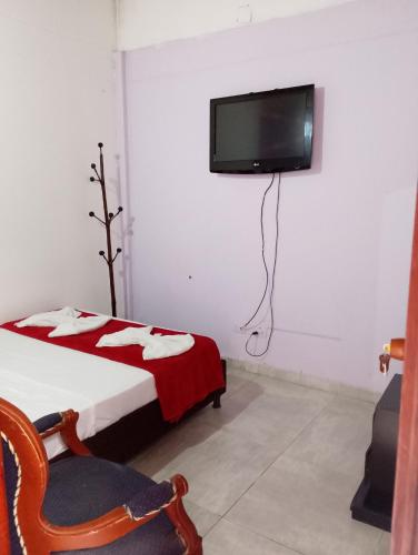 a bedroom with a bed and a tv on the wall at Alojamiento donde Nur in Filandia