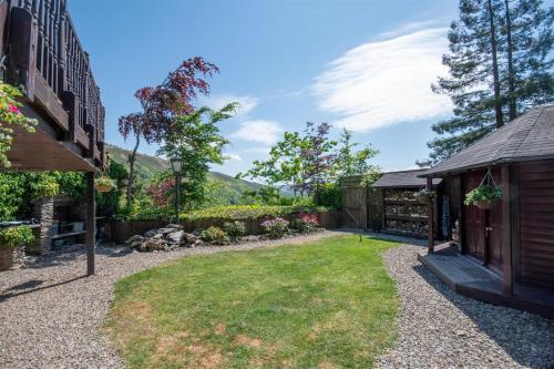 a backyard with a house and a grass yard at Horseshoe Pass Holiday Lets in Llangollen