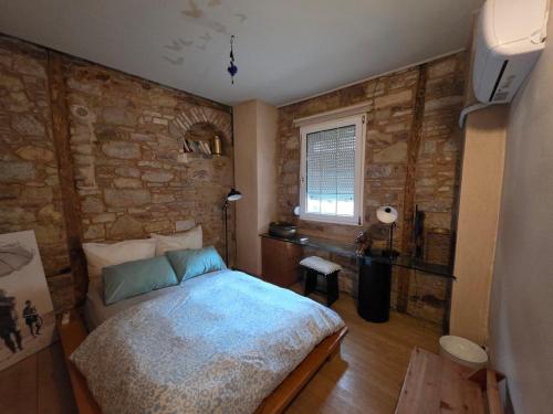 a bedroom with a bed and a stone wall at Homeric poems Suites in Chios
