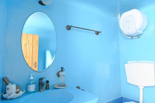 a blue bathroom with a mirror and a sink at Utopia Kythnos Althea in Kithnos