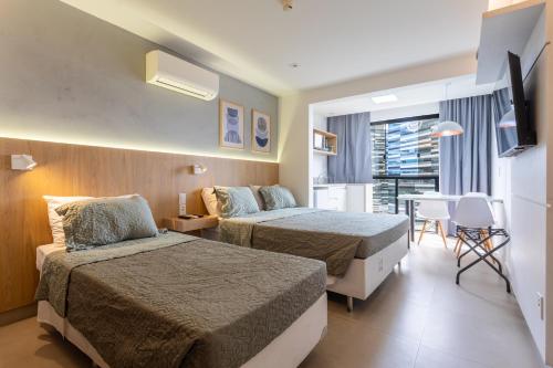 a hotel room with two beds and a table at Flat Central Arena Policia Federal in Brasília