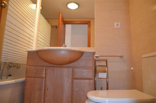 ein Badezimmer mit einem hölzernen Waschbecken und einem WC in der Unterkunft Albatros Playa 3 - 6008 in Mar de Cristal