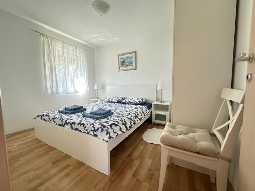 a white bedroom with a bed and a window at Apartment Vito in Mandre
