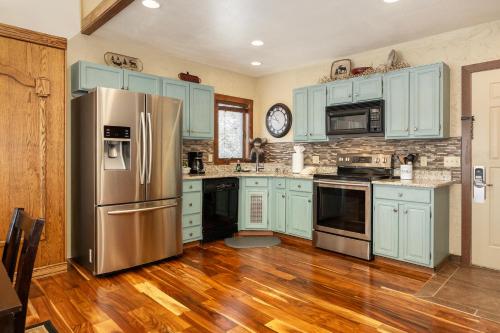 a kitchen with blue cabinets and a stainless steel refrigerator at Mountainside Unit B-8 in Granby