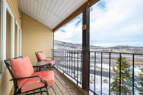 a balcony with two chairs and a table with a view at Mountainside Unit B-8 in Granby