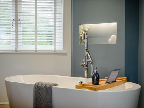 a bathroom with a tub with a laptop on it at 2 Bed in Weymouth oc-75201 in Weymouth