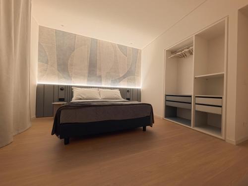 a bedroom with a bed and a painting on the wall at Loft 26 Apartment in Caltanissetta