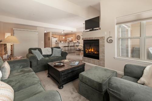 a living room with couches and a fireplace at Waterside West A206 in Fraser