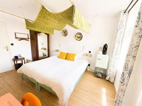 a bedroom with a large white bed with yellow pillows at Maison Georges in Tourcoing