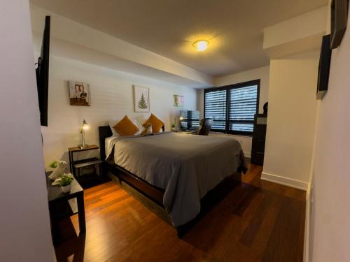 a bedroom with a large bed and a window at Core Downtown Toronto-8 Sleeper-4 Beds-2 Bathrooms-Washrooms-Free Parking-CN Tower-Ripleys Museum-Blue Jays Stadium In front-Indoor Gym-Swimming Pool-Jacuzzi Sauna-Filter Drinking Water-WiFi in Toronto