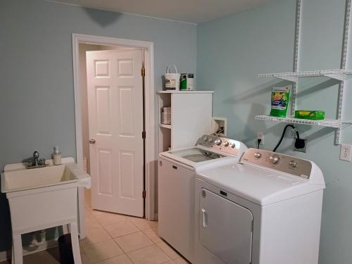 a kitchen with a washing machine and a sink at Beach Hoppers' Hideaway in Cape Charles