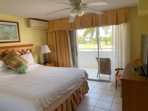 a bedroom with a bed and a table and a window at Beachfront Condo in Simpson Bay, SXM - 2BR 2BA in Simpson Bay