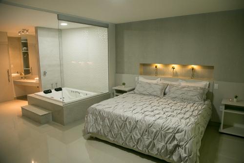 a bedroom with a bed and a bath tub at Peçanha Grande Hotel in Peçanha