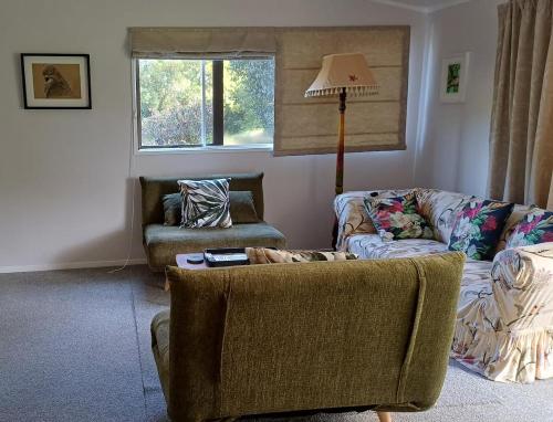 a living room with two couches and a lamp at Amblers Rest Accomodation in Drury