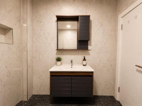 a bathroom with a sink and a mirror at Lumiera Suites Hotel in Nilüfer