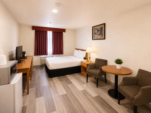 a hotel room with a bed and a desk at Ace Inn in Fort McMurray
