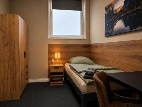 a small bedroom with a bed and a window at HK-Vermietung - dezent, ordentlich und preiswert mit allem, was es wirklich braucht in Brieselang