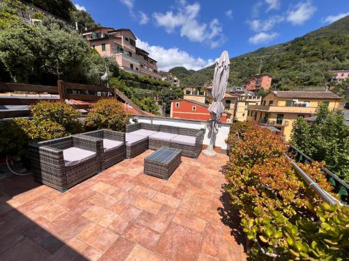 a patio with two couches and an umbrella at LE CINQUE VELE ***** Cinque Terre in Monterosso al Mare