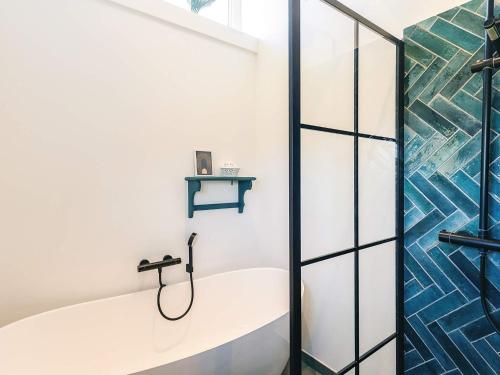 a bathroom with a tub and a glass shower door at 6 person holiday home in Vinderup-By Traum in Vinderup