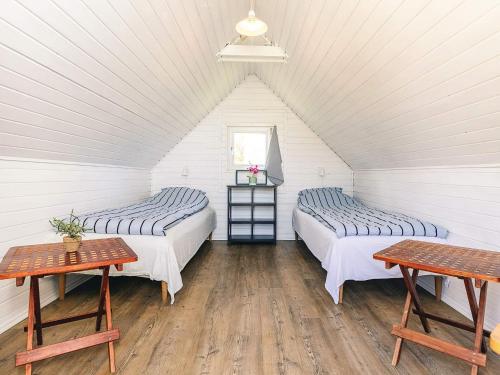 two beds in a room with white walls and wooden floors at 6 person holiday home in Vinderup-By Traum in Vinderup