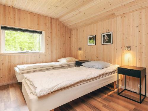 two beds in a room with wooden walls at 12 person holiday home in Idestrup-By Traum in Bøtø By