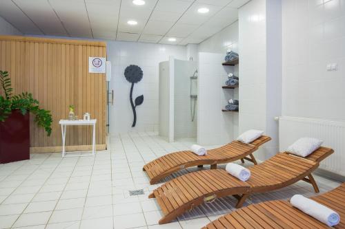 a room with two wooden benches and a shower at Mercure Karpacz Skalny in Karpacz