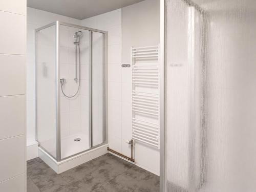 a white bathroom with a shower and a glass door at HK-Vermietung - dezent, ordentlich und preiswert mit allem, was es wirklich braucht in Brieselang