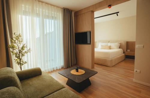 ein Wohnzimmer mit Sofa und Bett in der Unterkunft Noir Hotel in Gjakove