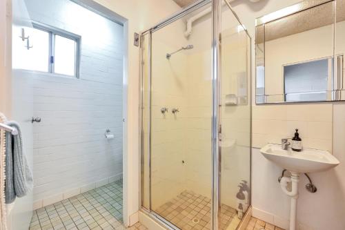 a bathroom with a shower and a sink at Beachfront Bliss Studio Apt on the Foreshore in Nightcliff