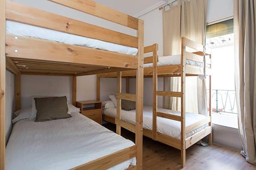 1 Schlafzimmer mit 2 Etagenbetten und einem Fenster in der Unterkunft Apartamento San Clemente in Sevilla